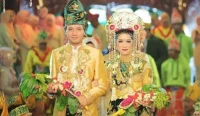 Pasangan pengantin Banjar mengenakan pakaian adat Kalsel Bagajah Gamuling Baular Lulut lengkap dengan mahkota ular dan rangkaian bunga melati mawar